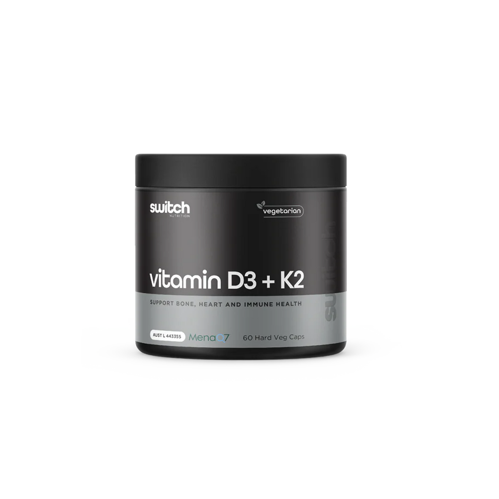 Black supplement container labeled 'vitamin D3 + K2' by switch on a white background